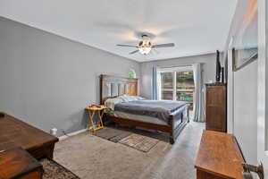 Primary bedroom with carpet flooring, access to private balcony, and primary bathroom