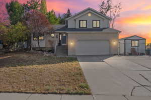 View of front facade with concrete driveway, brick siding, and a garage