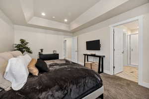 Tiled bedroom with recessed lighting, carpet flooring, and a tray ceiling