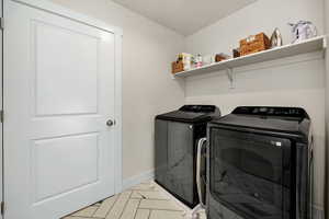 Washroom featuring washer and clothes dryer and light tile patterned floors