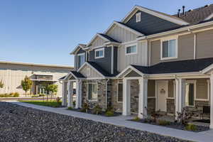 Craftsman-style house with board and batten siding, roof with shingles, stone siding, and a porch