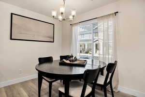 Dining room with light wood-style floors and a chandelier