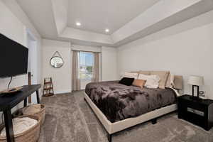Carpeted bedroom featuring a tray ceiling and recessed lighting
