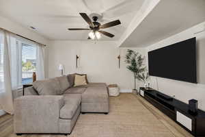 Living area with light wood finished floors and a ceiling fan