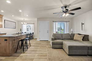 Living room featuring plenty of natural light, recessed lighting, light wood-type flooring, a chandelier, and ceiling fan