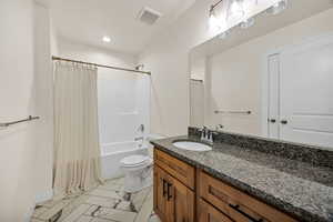 Bathroom with shower / bath combo with shower curtain, vanity, and recessed lighting
