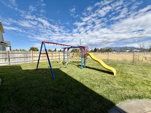 Communal playground with a fenced backyard and a mountain view