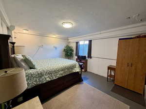 Bedroom featuring a textured ceiling and concrete flooring