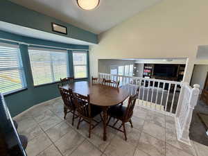 Dining room featuring vaulted ceiling and tile patterned flooring