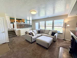 Living room with a textured ceiling and dark carpet