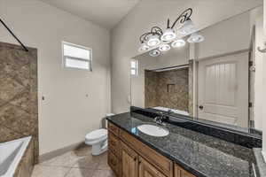 Bathroom featuring vanity, light tile patterned floors, and tiled shower / bath combo