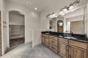 Full bathroom with double vanity, light tile patterned floors, and recessed lighting