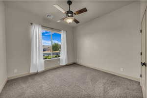 Spare room with light carpet, a ceiling fan, and vaulted ceiling