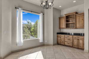 Unfurnished dining area featuring a chandelier, light tile patterned floors, and recessed lighting
