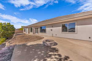 Back of property with stucco siding and a fire pit