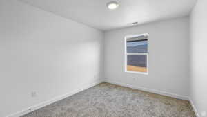 Spare room featuring carpet flooring and a textured ceiling