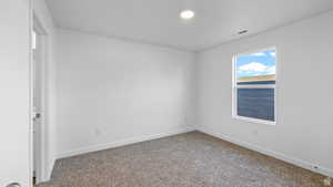 Empty room featuring baseboards and carpet flooring