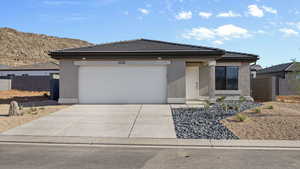 Prairie-style house featuring stucco siding, a tile roof, concrete driveway, and an attached garage