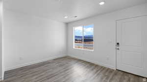 Entrance foyer with a mountain view, light wood-style floors, and recessed lighting