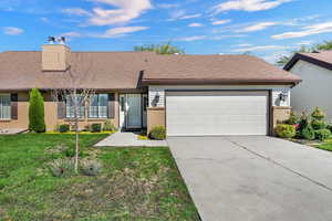 View of front of property featuring brick siding, concrete driveway, and an attached garage