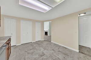 Unfurnished bedroom featuring two closets and a tiled fireplace