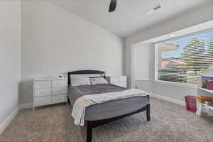 Bedroom featuring lofted ceiling, light colored carpet, a ceiling fan, and a textured ceiling