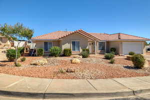 Ranch-style home with stucco siding, an attached garage, a tile roof, and driveway