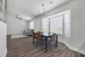 Dining room with a chandelier, a ceiling fan, dark wood-type flooring, a textured ceiling, and lofted ceiling
