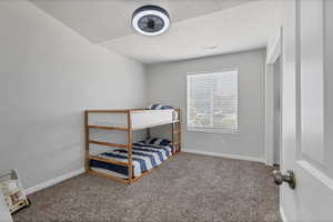 Carpeted bedroom with a textured ceiling and baseboards