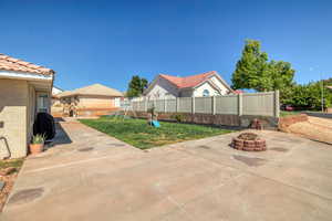 View of patio with a playground and a fire pit