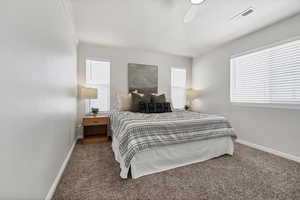 Carpeted bedroom featuring a ceiling fan and a textured ceiling
