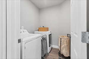 Laundry room featuring dark wood-type flooring and washing machine and dryer