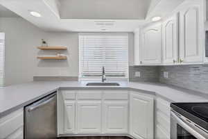 Kitchen with open shelves, appliances with stainless steel finishes, white cabinetry, recessed lighting, and backsplash