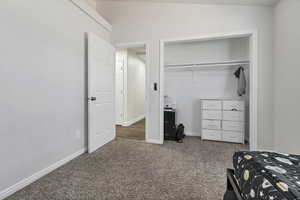 Bedroom featuring dark carpet and a closet
