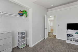 Unfurnished bedroom with carpet flooring and baseboards