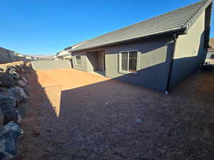 Back of house featuring a tiled roof, stucco siding, a patio, and a fenced backyard