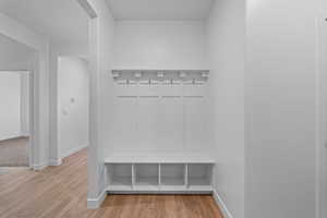 Mudroom featuring light wood finished floors and baseboards
