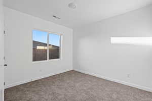 Spare room featuring carpet floors and baseboards