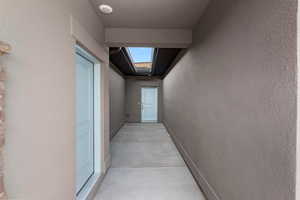Hall featuring a skylight and a textured wall
