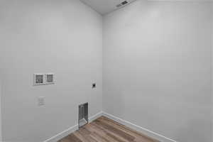 Washroom featuring light wood-style floors, hookup for a washing machine, and electric dryer hookup