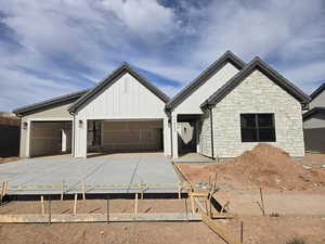 Modern farmhouse with driveway, board and batten siding, and an attached garage
