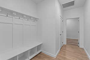 Mudroom featuring light wood-style floors and baseboards