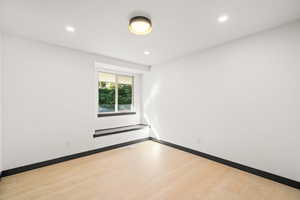Empty bedroom 3 featuring light wood finished floors and recessed lighting