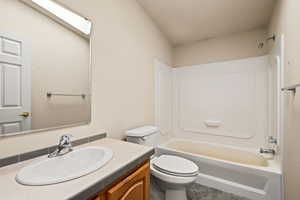 Full bathroom featuring shower / washtub combination, vanity, a skylight, and a textured wall