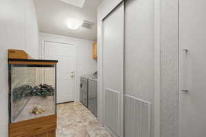 Laundry area with separate washer and dryer, cabinet space, crown molding, and a textured ceiling