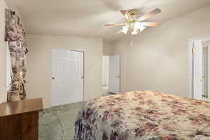 Carpeted bedroom with vaulted ceiling and ceiling fan