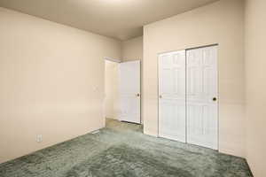 Unfurnished bedroom featuring carpet flooring and a closet