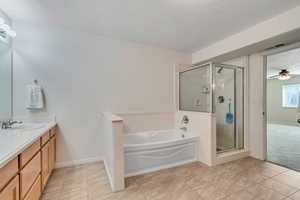 Full bathroom with a garden tub, vanity, a ceiling fan, a shower stall, and light tile patterned flooring