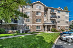 View of apartment building / complex featuring uncovered parking
