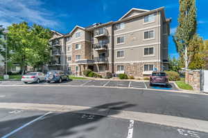 View of apartment building / complex featuring uncovered parking